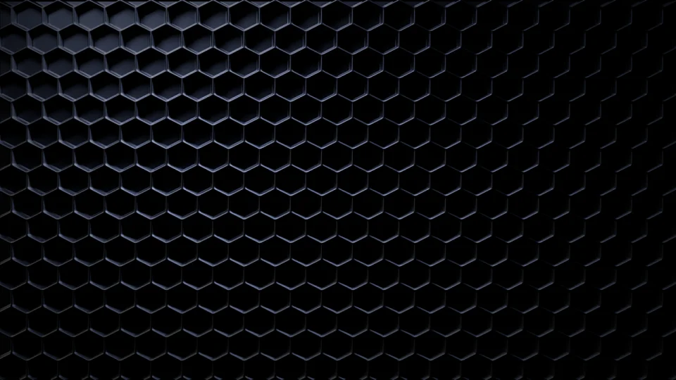 Close-up of a black honeycomb pattern with hexagonal shapes, creating a textured surface.